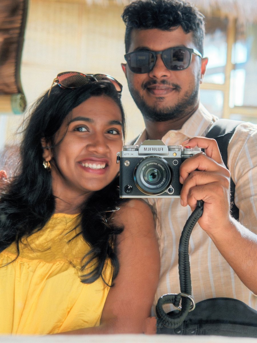 Stive and Shirley in a bamboo hut in Bali, holding a camera to the lens